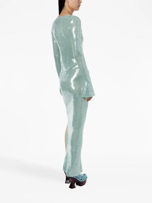 Person wearing a light green sequin outfit on a white background
