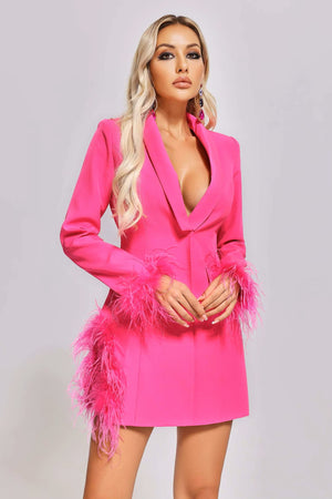 Woman wearing a bright pink dress with feather details on a plain background