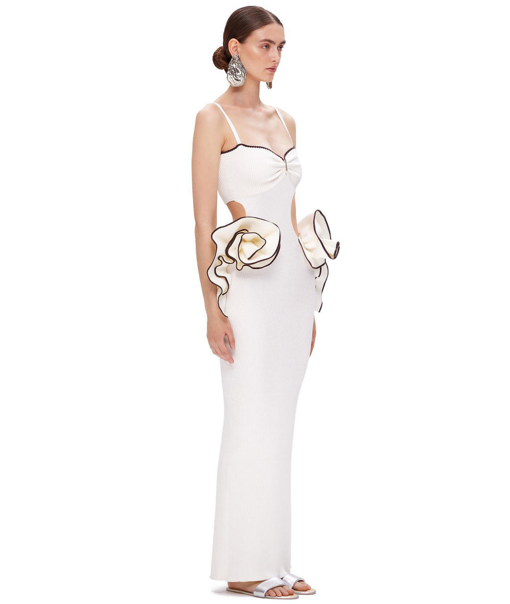 White evening gown with cut-out design and large gloves on a white background