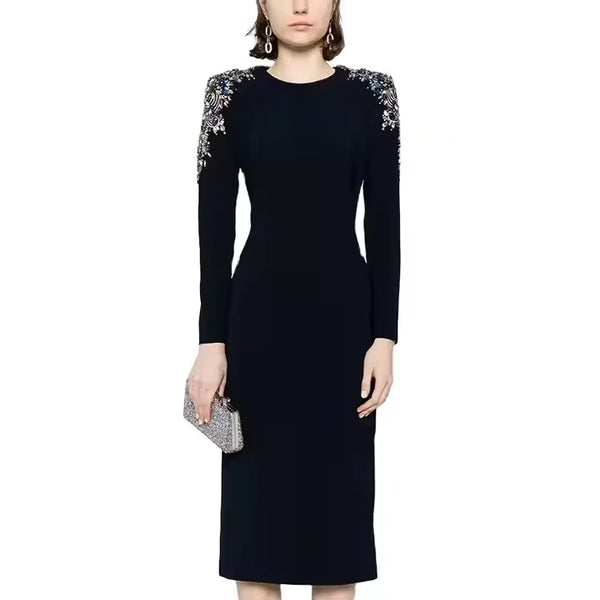 Black dress with floral embellishments on shoulders against a white background