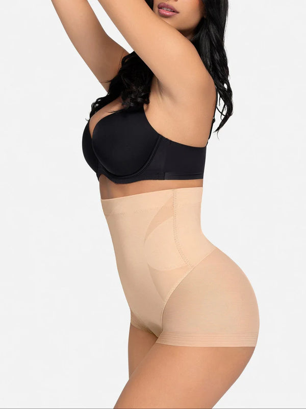 Woman wearing a black bra and beige shapewear on a white background
