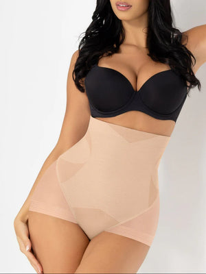 Woman wearing a black bra and beige shapewear on a white background